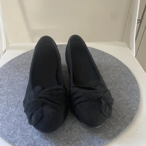 Svarta ballerinaskor - Stilrena svarta ballerinaskor med rund tå framtill. Skorna är i mockaimitation och har en klassisk, enkel design som passar till många outfits. Perfekta för dig som gillar en clean och tidlös look. Storlek 36, pris kan diskuteras!🥰