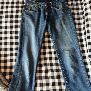 Levi's 511 blå jeans W32 L36 - Snygga blå Levi's 511 jeans med klassisk femficksdesign och raka ben. Jeansen har en mellanblå tvätt och är tillverkade i slitstarkt bomullsjeans. Perfekta för dig som gillar en tidlös och clean look.