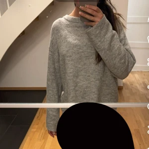 Grå stickad oversized tröja - Mysig grå stickad tröja med oversized passform och långa ärmar. Perfekt för lager-på-lager och chill dagar. Enkel design med rund halsringning och mjukt material som känns skönt mot huden.