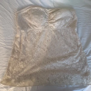Beige sommartopp  - Superfin axelbandslös sommartopp med beiget blommigt spetsmönster. Det finns ett extra lager med tyg vid bysten, så det syns inte igenom. Priset kan diskuteras🫶
