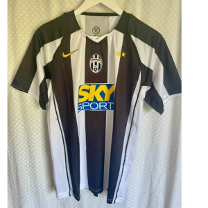 Vintage Jersey Juventus FC   - Juventus fc hemmatröja säsong 2004/2005 med svarta och vita ränder, officiell Ibrahimovic 9 på ryggen. Nike-logga i gult, klubbmärke och två stjärnor på bröstet samt Sky Sport sponsortryck. Klassisk passform i lätt och ventilerande material.