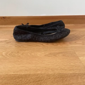 Svarta spetsballerinaskor Atmosphere - säljer snygga svarta ballerinaskor från Atmosphere med spetsdetaljer och liten rosett framtill. Skorna har rund tå och platt sula💗