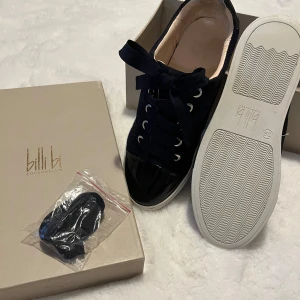 Marinblåa sneakers från Billi Bi - Snygga marinblåa sneakers från Billi Bi med mocka och lackdetaljer på tå och häl. Skorna har breda marinblåa snören och vit sula. Kommer med extra skosnören och originalkartong. Perfekta för en trendig och stilren look. Säljer då dom är för stora, använda fåtal gånger.