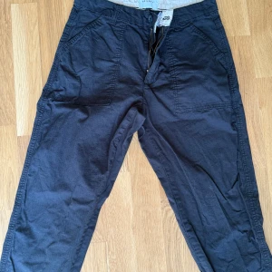 Svarta cargopants från Vailent - Snygga svarta cargopants från Vailent med raka ben och stora fickor både fram och bak. Byxorna har dragkedja och knapp i midjan samt bälteshällor. Perfekta för en avslappnad och cool stil.