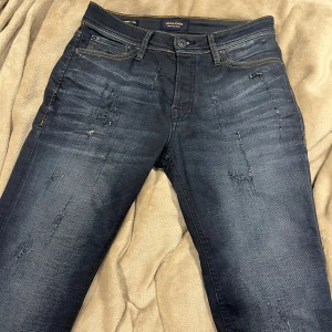 Jack & Jones Slim/straight - Riktigt feta Mörkblå jeans från Jack & Jones i modellen Slim Straight Tim. Jeansen har slitna detaljer framtill, och en riktigt snygg och stilren mörkblå färg, jeansen finns ej att köpa längre och finns bara ett väldigt limiterat antal köpta för 1000kr mitt pris 350
