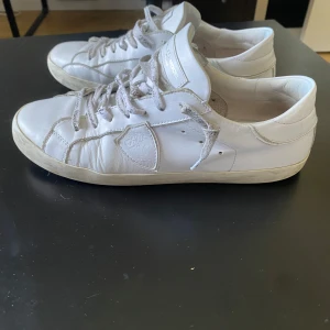 Vita Philippe Model sneakers  - Säljer mina snygga vita sneakers från Philippe Model som har blivit för små. Klassisk låg modell med rund tå, snörning och diskret logga på sidan. Sulan är svart undertill. Perfekta för en clean och stilren look nu till sommaren. Skriv vid minsta fundering!