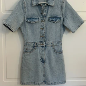  Jeansklänning från Mango - Superfin ljusblå jeansklänning från Mango. Klänningen har korta ärmar, knappar framtill och fickor både fram och bak. Med lappen kvar!