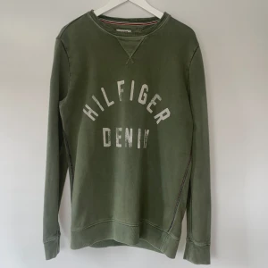 Grön Tommy Hilfiger tröja  - Säljer denna mörkgröna Tommy Hilfiger tjocktröja. Storlek S men är väldigt stor i storlek så passar M också. En äldre tröja i bra skick. 