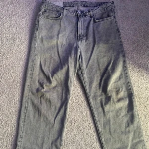 Grå loose fit jeans från H&M - Säljer ett par grå jeans från H&M i loose fit-modell. Jeansen har klassisk femficksdesign, raka ben och är tillverkade i denim. Perfekta för dig som gillar en avslappnad och trendig stil.
