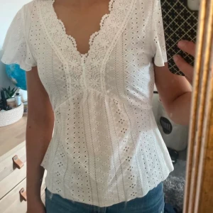 Vit spetsblus med v-ringning - Superfin blus med mönster, v-ringning och lite utsvängd. Har en jättefin passform och är jättesomrig. Ser helt oanvänd ut! Kontakta för frågor eller fler bilder❤️