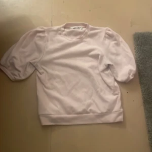 Ljusrosa tröja från 157 med puffärm - Supersöt ljusrosa tröja från 157 med puffiga korta ärmar och rund halsringning. Den är ganska liten i storleken så den är som S/M