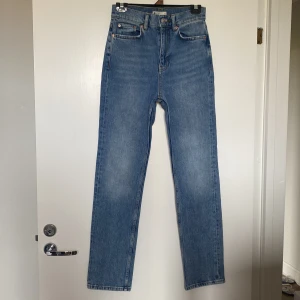 Blå high waist raka jeans från Gina Tricot storlek 34 - Snygga blå jeans från Gina Tricot med hög midja och raka ben. Klassisk femficksmodell i ljusblå tvätt, tillverkade i jeansmaterial. Perfekta för en clean och tidlös look.