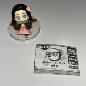 Nezuko Kamado figur - Snygg och detaljerad Nezuko Kamado-figur från Demon Slayer: Kimetsu no Yaiba! Perfekt för animefans och samlare. Figuren har coola färger och står på en genomskinlig bas. Ett måste för dig som älskar manga och anime! Figuren är köpt på Science Fiction Bokhandeln och är ca 5cm hög.