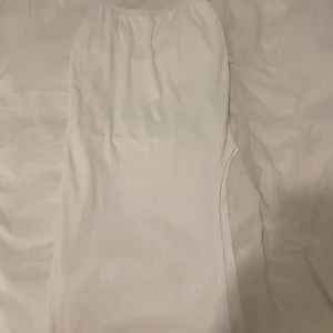 Vit omlottkjol från SHEIN - Snygg vit omlottkjol från SHEIN i storlek S. Kjolen har en enkel och stilren design med omlott-detalj och resår i midjan. Perfekt för dig som gillar minimalistisk stil och vill ha något fräscht till sommaren.