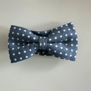 Prickig fluga - Festlig blå fluga med vita prickar. Flugan har en justerbar rem för att passa olika halsstorlekar. Ny i förpackning.  Hämtas i Stockholm eller skickas mot porto.