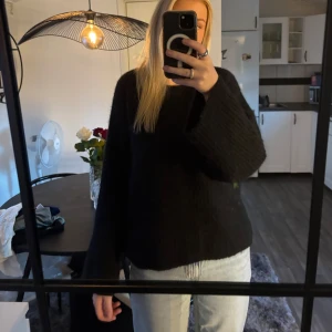 Svart stickad tröja med rosett i ryggen - Svart stickad tröja från Gina med oversized passform och långa ärmar. Tröjan har en djup öppen rygg med en bred svart rosett som knyts i nacken. Sparsamt använd, i storlek XS🖤