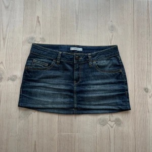 Mörkblå lågmidjad jeanskjol  - Blå jeanskjol från Esprit i fint skick. Kan inte hitta storlek men skulle säga M, passar även S. Tvärs över midjan är det 42 cm och den är ca 31 cm lång (längs med sidan). Fint skick. Använd gärna köp nu!