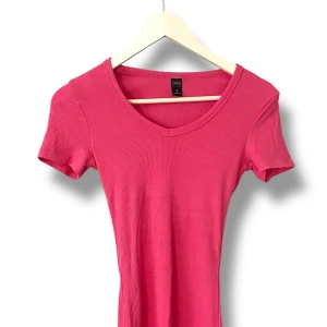 Rosa ribbad topp från Dazy - En snygg rosa klänning från Dazy med ribbad struktur och v-ringning. Modellen är figurnära med korta ärmar och stretchigt material som sitter skönt. Perfekt till sommaren