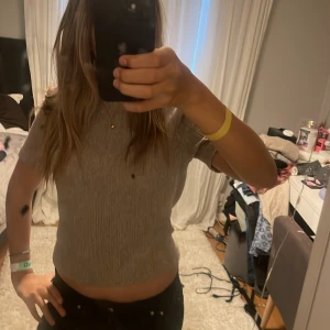 Beige ribbad kortärmad topp - Säljer en beige ribbad topp med korta ärmar och rund hals. Toppen har en croppad passform och är superenkel att matcha med både jeans och kjol. Perfekt för dig som gillar en clean och stilren look.