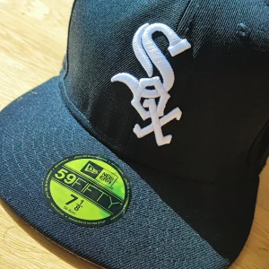 Chicago White Sox keps New Era 59FIFTY - PRIS KAN DISKUTERAS.                                                    Svart New Era 59FIFTY keps med Chicago White Sox broderad logga i vitt framtill och broderade detaljer på sidan med texten 'Chicago Southside'. Klassisk flat peak och cool streetstyle-vibe. Kepsen är i storlek 7 1/8 (56,8 cm) och har en grym passform.