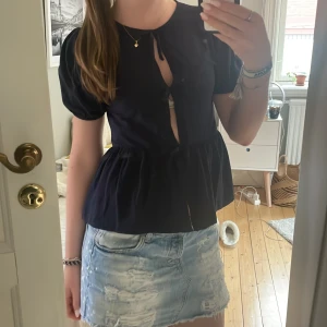 Mörkblå blus med knyt från Gina Tricot - Supersöt mörkblå blus från Gina Tricot med puffiga korta ärmar och tre knyt framtill. Endast använd 1 gång då jag ej fått användning för den, hör av er vid frågor 💕