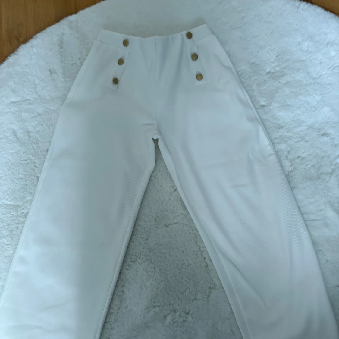 Vita byxor med guldknappar