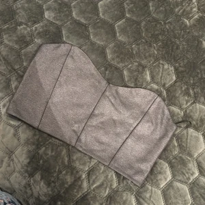 Glittrig silver tubtopp från Gina Tricot - Säljer en snygg glittrig silverfärgad tubtopp från Gina Tricot. Toppen är axelbandslös och har en figurnära passform, perfekt för att sticka ut. Materialet är glittrigt och ger en festlig känsla.