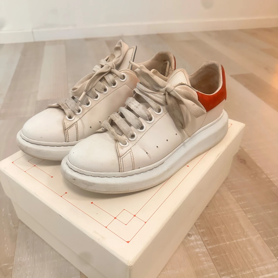 Vita sneakers från Alexander McQueen med röd häl
