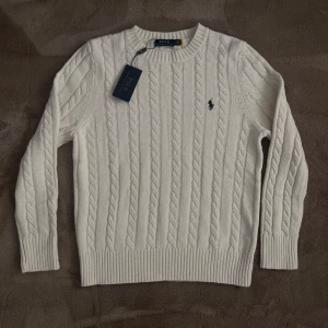 Vit Ralph Lauren Kabelstickad Tröja - Helt ny vit kabelstickad Ralph Lauren tröja. Den är i Strl M men kan eventuellt passa S då ullen är stretchig. Tags tillkommer. Vid frågor eller funderingar skicka ett pm, Mvh