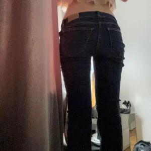 Mörkblå jeansbyxor med normal passform - Säljer ett par mörkblå jeansbyxor med klassisk femficksdesign och normal passform. Byxorna har knapp och dragkedja framtill samt raka ben. Perfekta för en stilren och enkel look.