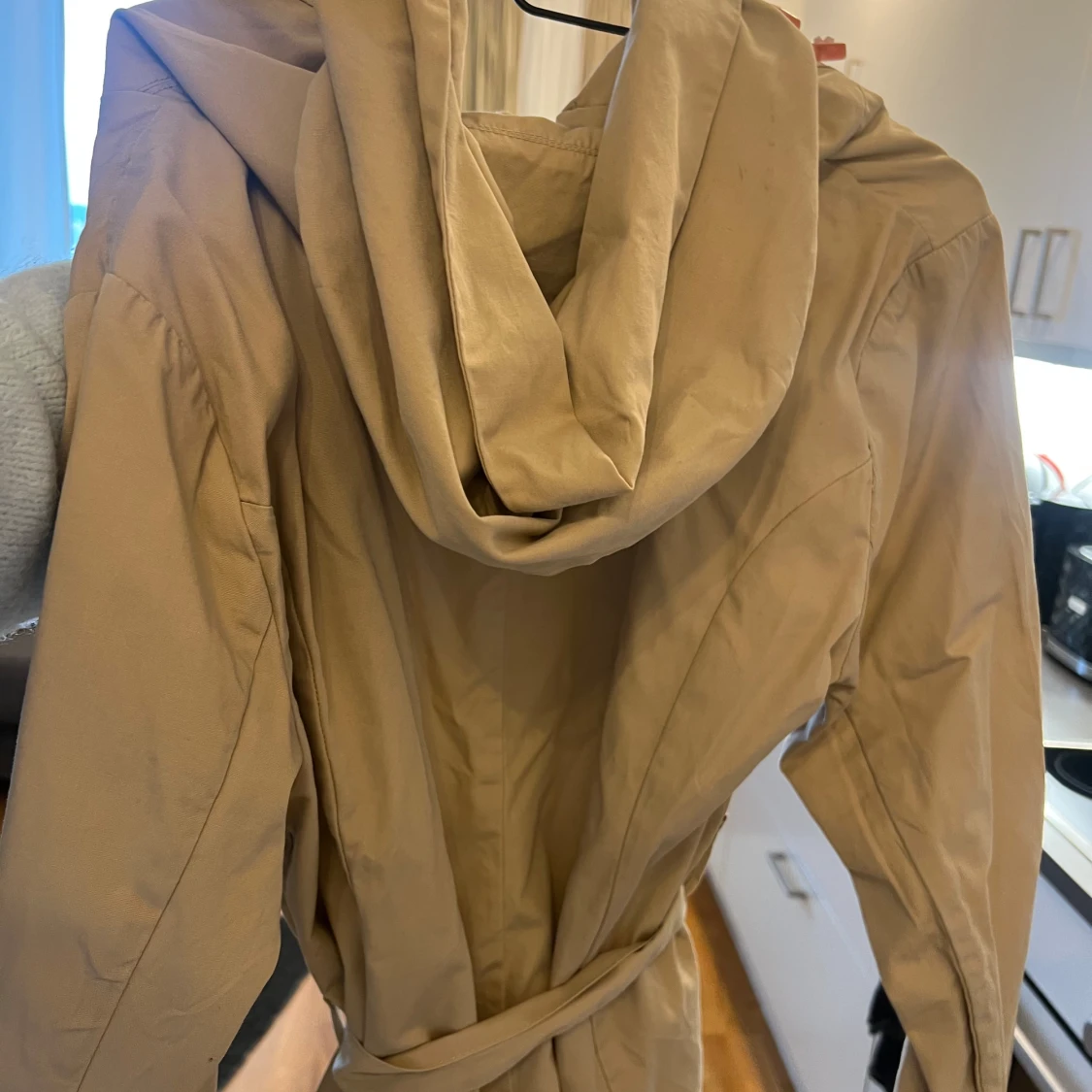 Beige trenchcoat med bälte och huva - 1