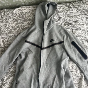 Grå Nike tech kofta  - Jag säljer den för att den inte används, inget fel på den fungerar som den ska och ser ut som den ska. 