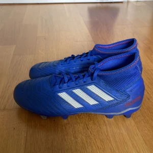 Adidas predator 19.3 FG/AG EXHIBIT-BLÅ,SILVER,RÖD STORLEK 39 1/2 - Säljer ett par fotbollsskor som är blåa, silvriga och röda. Säljer dem väldigt billigt för att dem är andvända ett fåtal gånger. Kontakta mig om ni har några frågor!⚽️
