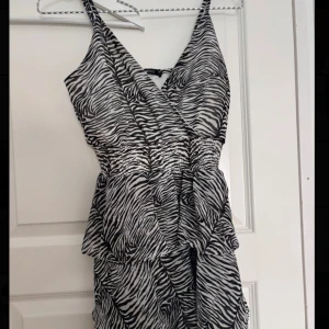 Kort volangklänning - Säljer en kort svartvit zebramönstrad klänning med volangdetaljer. Klänningen har markerad midja i strestchigt material!🦓