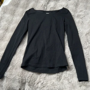 Svart långärmad topp från 157 - En enkel svart långärmad topp från 157 i mjuk bomullsblandning med rund halsringning. Perfekt basplagg att ha i garderoben och lätt att matcha med olika outfits.