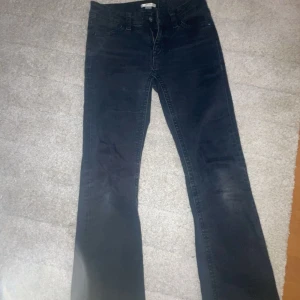 Gina Young jeans - Snygga svarta jeans från Levis med klassisk femficksdesign och bootcut-ben. Jeansen har en mörk tvätt och tydliga sömmar på bakfickorna. Lite slitna längst ner där av billigare pris 