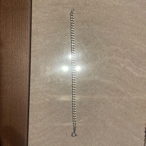 Klassiskt silverfärgat armband - Snyggt armband i silverfärg med platta, tätt länkade kedjor och rund låsring. Perfekt accessoar för en clean och stilren look. Passar både tjejer och killar som gillar minimalistiska smycken.