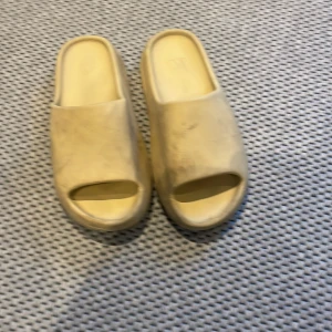 Beige Adidas Yeezy Slides - Säljer ett par beige Adidas Yeezy Slides med chunky, Passar 40,5-42 Yeezy-looken.