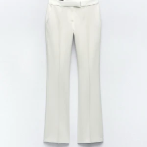 Vita kostymbyxor från Zara - Snygga vita kostymbyxor från Zara i storlek S. Byxorna har raka ben med lätt bootcut och diskreta fickor i sidorna.