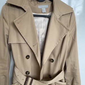 Vårkappa Beige strl. 36 - Väldigt fin kappa/trenchcoat till våren i beige färg strl. 36. Enstaka gånger använd. Jättefin och ren. 