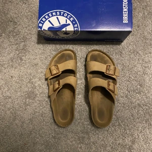 Birkenstock Arizona sandaler tobacco brown - Birkenstock Arizona sandaler i färgen Tobacco Brown. Klassisk modell med två justerbara remmar och metallspännen. Perfekta för sommaren och riktigt sköna att gå i. Använda ett fåtal gånger. Säljer då de inte kommer till användning. 