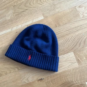 Ralph lauren mössa - Hej säljer denna navyblue ralph lauren mössan. No size. Perfekt för vinter. Säljer billigt då de sommar nu. Köpt för 999kr. Skick 10/10. Som nytt