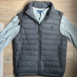 Polo Ralph Lauren Väst - Mörkgrå väst från polo Ralph Lauren i storlek XS/TP. Passar mig perfekt som är 177cm 56kg. Riktigt bra skick utan defekter, sparsamt andvänd. Nypris: 1899kr. Mitt pris: 799kr PRUTBART✅