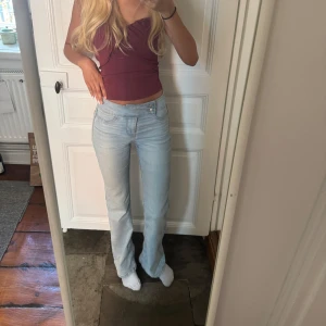 Ljusblå bootcut jeans med hög midja - Säljer ett par ljusblå jeans med bootcut-modell och medelhög midja. Jeansen har klassiska fickor fram och bak samt dubbla knappar i midjan. Innerbenslängden: 79cm, midja rakt över: 34cm☺️