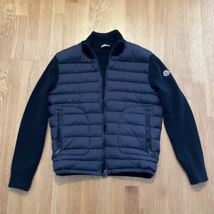 Moncler Cardigan - Säljer denna fina Moncler Cardigan i färgen - Navy Blue. Jackan är använd under ett tillfälle och är väl omhändertagen. Säljer den eftersom den passar inte mig som jag vill!