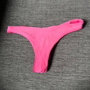 Rosa bikiniunderdel med scrunch - Säljer en snygg bikiniunderdel i stark rosa röd färg. Modellen är high cut med scrunch-detalj bak för en extra snygg passform. Perfekt för dig som vill ha en trendig och enkel bikiniunderdel till stranden eller poolen.