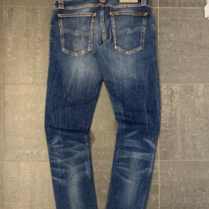Feta Nudie Jeans blå jeans - Säljer ett par as snygga jeans från nudie, storlek w27 L32. Passar dem storlekarna, Ksk något mindre i midjan. Om du har nån fråga så skriv så svarar jag så snabbt som möjligt!🙌