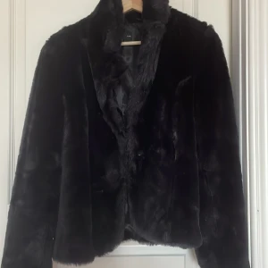 Svart pälsjacka med krage - Säljer en svart pälsjacka med bred krage och klassisk passform. Jackan är fluffig och ger en lyxig känsla, perfekt för kalla dagar. Enkel att styla till olika outfits och riktigt skön att bära. Skriv till mig för fler bilder eller info!🤍
