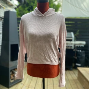 Ljusrosa ribbad hoodie från H&M 170cl - Ljusrosa ribbstickad hoodie med långa ärmar. Den har en avslappnad passform och är i storlek 170. Perfekt för en avslappnad och bekväm stil. Längd: 50 cm ﻿Bystvidd: 54 cm ﻿Resår i nederkant ﻿80% viskos, 18% polyester, 2% elastan  Inga bilder när den sitter på mig! Katter finns i hemmet!