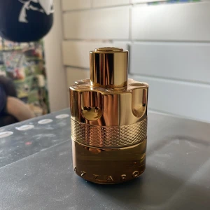 Azzaro Wanted Forever Elixir 50ml - Azzaro Forever Wanted Elixir är en parfym i en lyxig, guldig flaska med metallisk finish och detaljerad struktur. Flaskan rymmer 50 ml och har en robust, rund form med tydlig Azzaro-logga. Kommer med originalkartong i matchande guldton. Nästan Helt full använd 1 gång det var inte riktigt min doft men tror verkligen att andra tycker den är fantastisk 